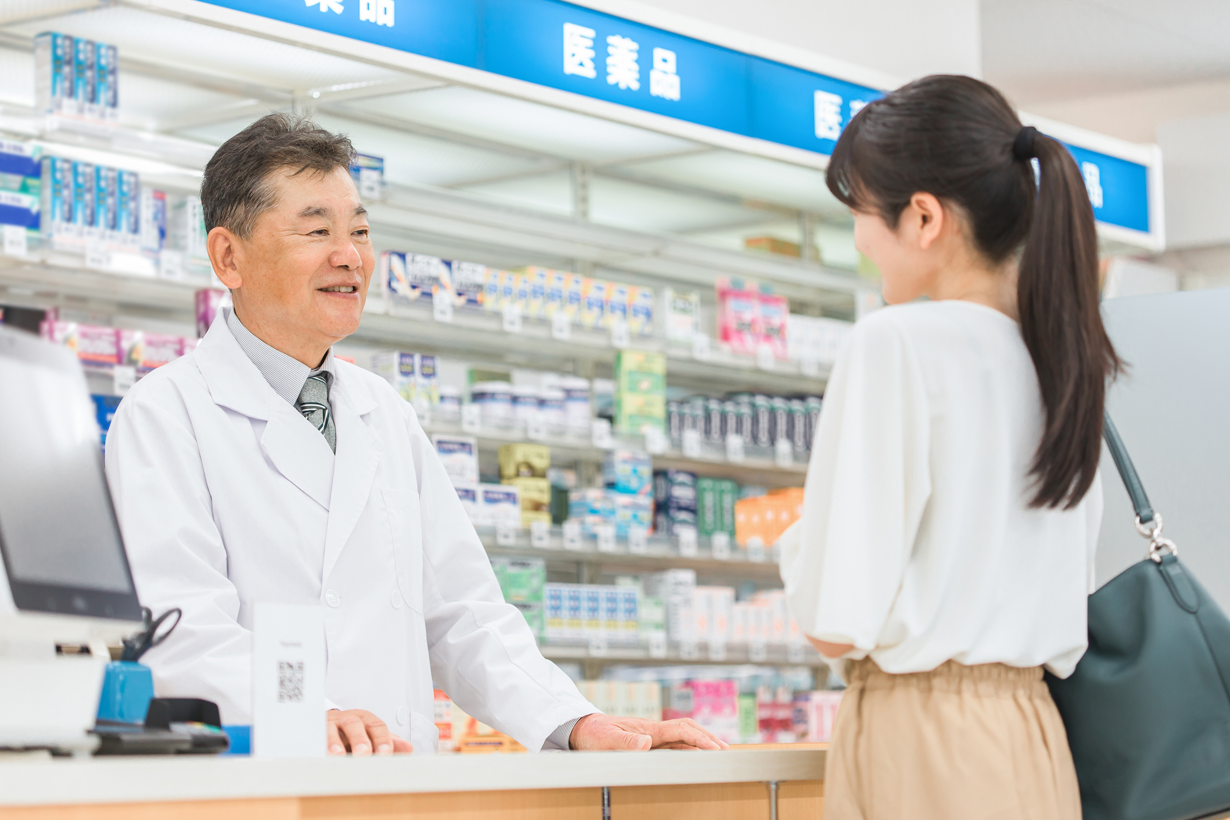 薬局で薬剤師に相談する男性